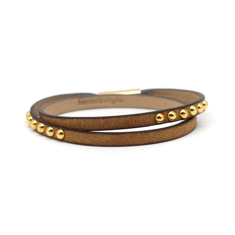 Bracelet en cuir artisanal pour femme Sirli avec un design à la fois classique et original. Made in France, haut de gamme. Couleur tabac, clous et fermoir dorés. Fabriquée en France.