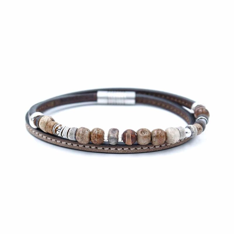 Bracelet en cuir artisanal et à perles pour homme Urubu avec un design à la fois classique et original. Made in France, haut de gamme. Couleur marron foncé et beige sable avec boucle argentée. Fabriqué en France.